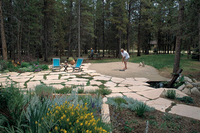 
Ann has worked diligently to create a garden in the tough, high-country climate. Rich spends many tranquil moments raking the sand in his Zen garden. The grass over the septic system and leach field in the background grows to only six inches high and never requires mowing.
